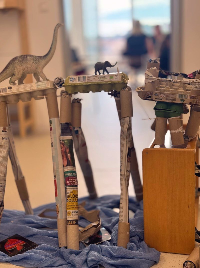 Türme aus Eierkartons und Papierrollen mit Dino und Elefant obendrauf
